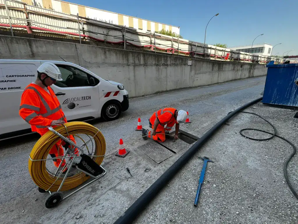 Technicien localisant une canalisation enterrée au détecteur électromagnétique